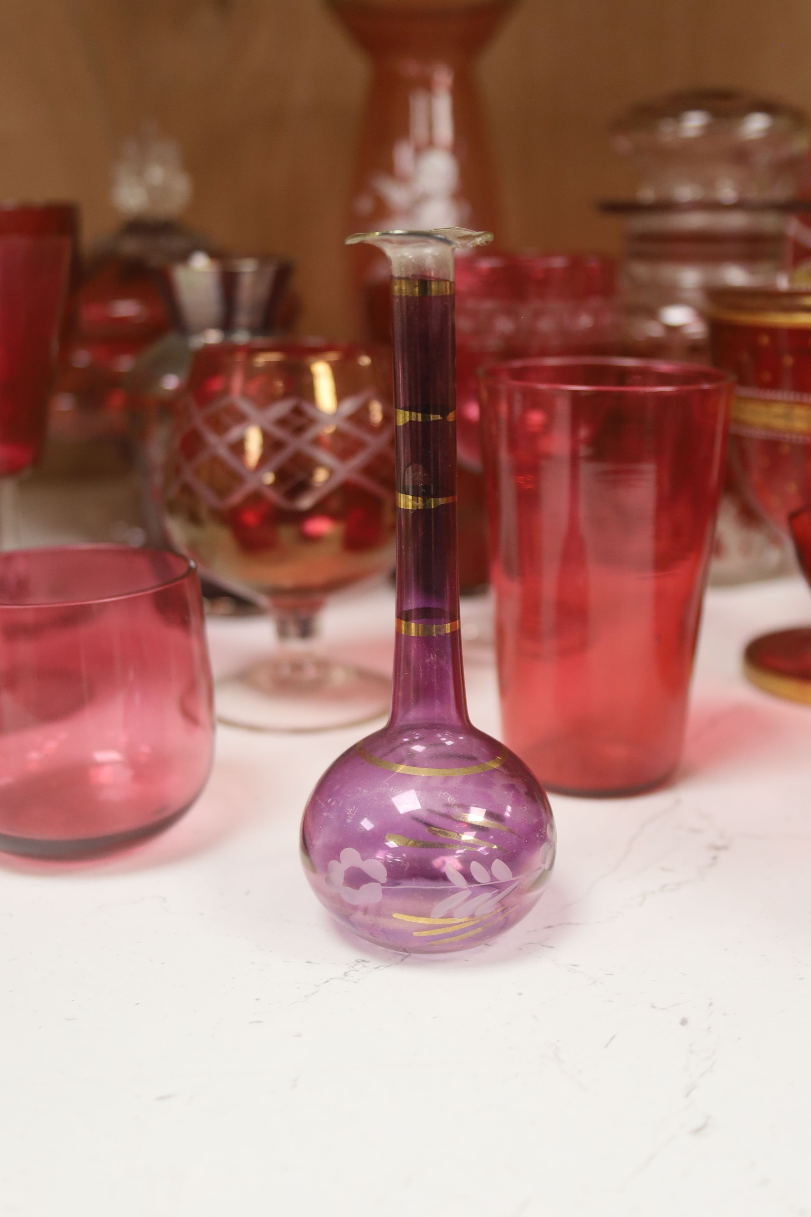 A collection of cranberry and ruby glassware including a 'Mary Gregory' vase